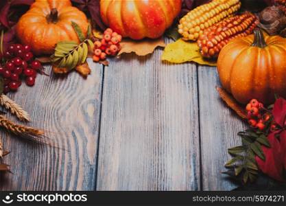Thanksgiving still life - berries, nuts, corn and pumpkins on a table