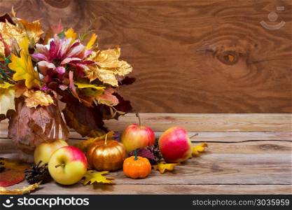 Thanksgiving table centerpiece with fall leaves bouquet. Thanksgiving or fall table centerpiece with silk flowers and fall leaves bouquet in the golden vase, copy space