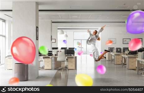 That feeling of freedom. Happy young businesswoman dancing in modern office