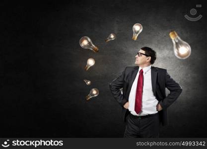 That is bright idea. Middle-aged businessman looking at glass glowing lightbulb