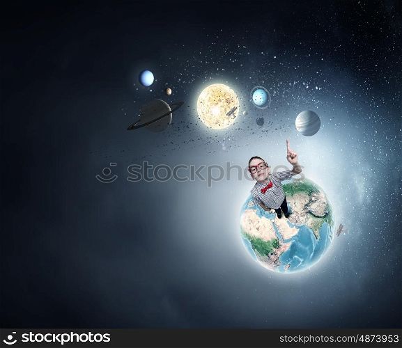 That is interesting point. Cute schoolboy in red glasses with finger pointing up. Elements of this image are furnished by NASA