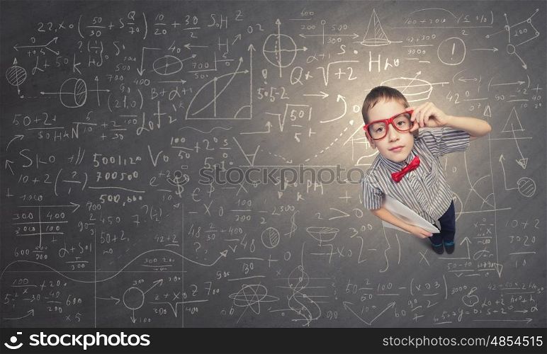 That is interesting point. Top view of cute schoolboy in red glasses on chalkboard background