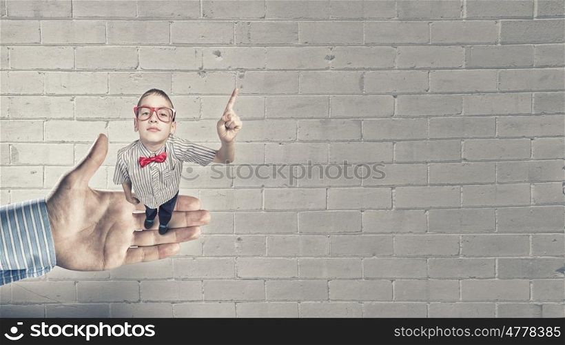 That is interesting point. Top view of cute schoolboy in red glasses with finger up