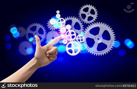 That&rsquo;s how it works. Close up human hand pointing at gears mechanism
