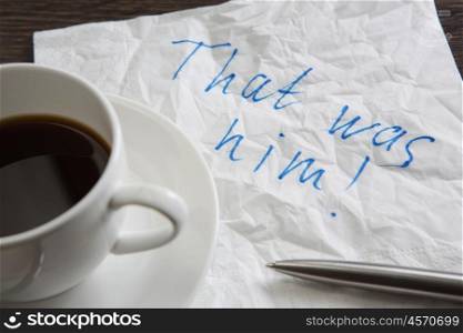 That was him. Message written on napkin and coffee cup on wooden napkin