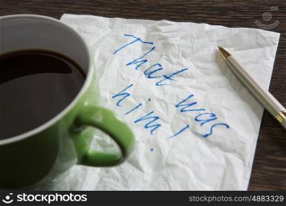That was him. Message written on napkin and coffee cup on wooden napkin