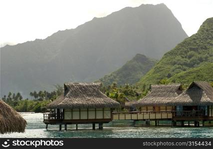 Thatched roof buildings built on stilts in the sea, Moorea, Tahiti, French Polynesia, South Pacific
