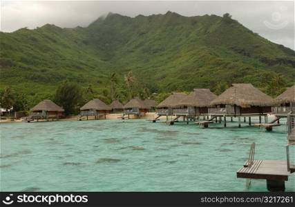 Thatched roof cottages built on stilts in the sea, Moorea, Tahiti, French Polynesia, South Pacific