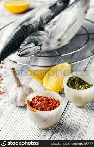 Thawed fresh fish mackerel with spices and marinade with lemon.Photograph high key. Carcasses frozen mackerel