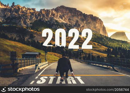 The 2022 New Year journey and future vision concept . Businessman traveling on highway road leading forward to happy new year celebration in beginning of 2021 for fresh and successful start .