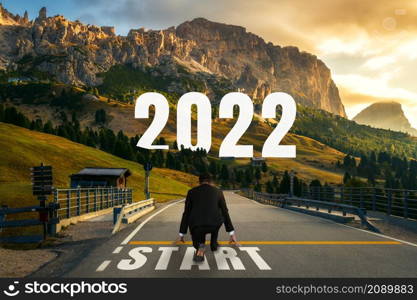 The 2022 New Year journey and future vision concept . Businessman traveling on highway road leading forward to happy new year celebration in beginning of 2021 for fresh and successful start .. The 2022 New Year journey and future vision concept