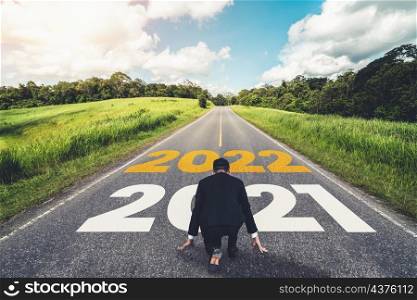 The 2022 New Year journey and future vision concept . Businessman traveling on highway road leading forward to happy new year celebration in beginning of 2021 for fresh and successful start .