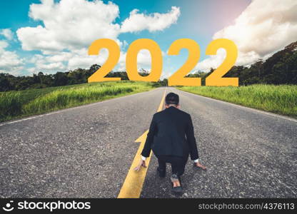 The 2022 New Year journey and future vision concept . Businessman traveling on highway road leading forward to happy new year celebration in beginning of 2021 for fresh and successful start .