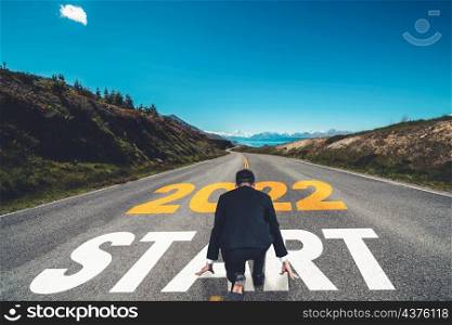 The 2022 New Year journey and future vision concept . Businessman traveling on highway road leading forward to happy new year celebration in beginning of 2021 for fresh and successful start .