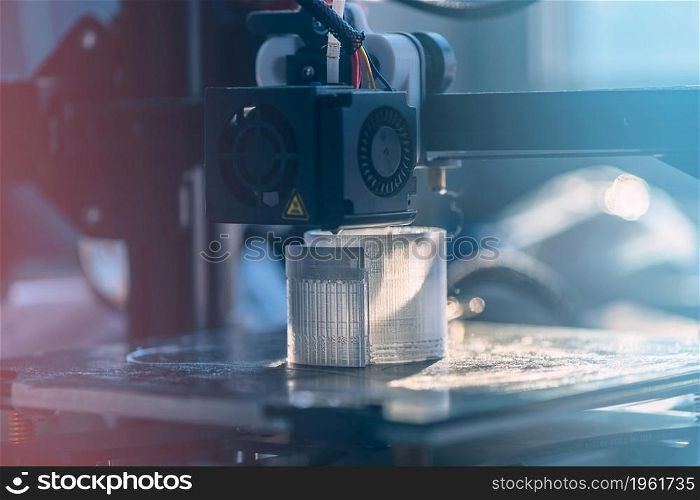 The 3D printer prints white transparent plastic model. modern technology. selective focus. The 3D printer prints white transparent plastic model