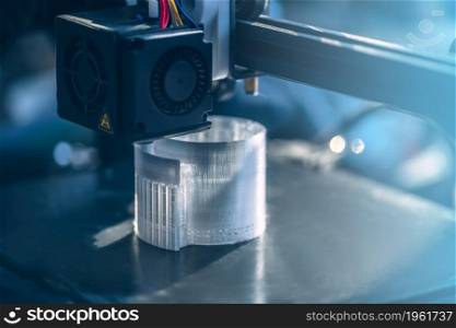 The 3D printer prints white transparent plastic model. modern technology. selective focus. The 3D printer prints white transparent plastic model