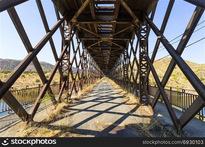 The abandoned road inside the truss bridge crossing the Douro River in Pocinho, Douro region, Portugal