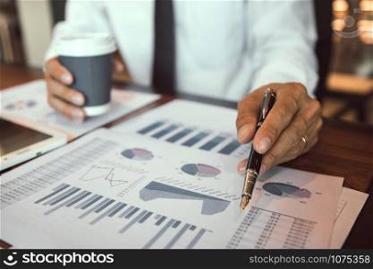 The accounting staff of the company are jointly analyzing the graph of the expenses on the desk in the office.