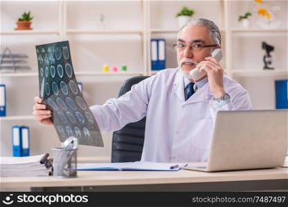 The aged male doctor radiologist in the clinic. Aged male doctor radiologist in the clinic