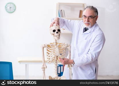 The aged male doctor with skeleton . Aged male doctor with skeleton 