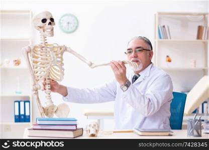 The aged male doctor with skeleton . Aged male doctor with skeleton 