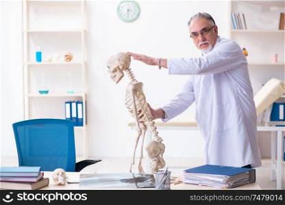 The aged male doctor with skeleton . Aged male doctor with skeleton