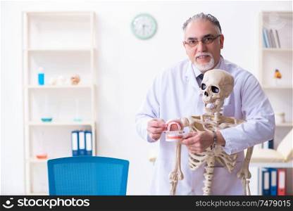 The aged male doctor with skeleton . Aged male doctor with skeleton
