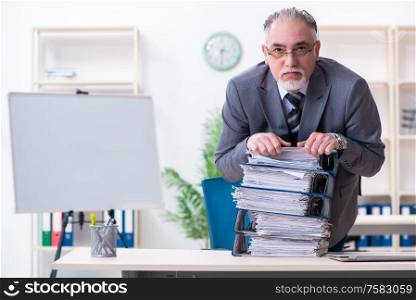 The aged male employee unhappy with excessive work. Aged male employee unhappy with excessive work