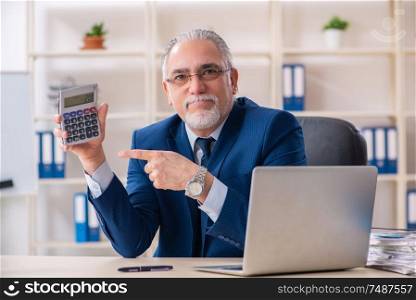 The aged male employee working in the office. Aged male employee working in the office
