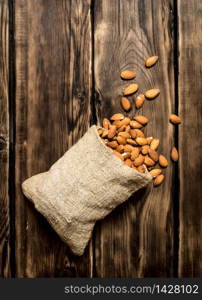 The almonds in an old bag. On a wooden table.. The almonds in an old bag.