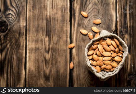 The almonds in an old bag. On a wooden table.. The almonds in an old bag.