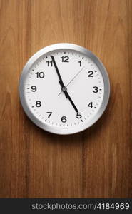 The aluminum wall clock is almost five.