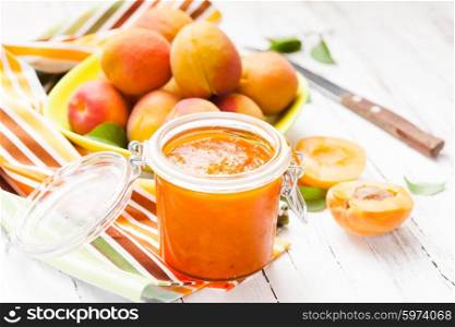 The apricot jam in glass jar and fruits. The apricot jam