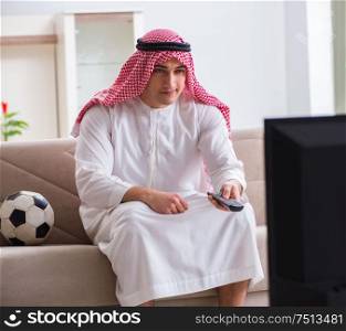 The arab businessman watching tv at home. Arab businessman watching tv at home