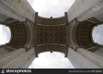 The arc de Triomphe on the Champs Elisee in Paris, France seen from dead center below, using a fish eye lens to show the imposing size of the monument.