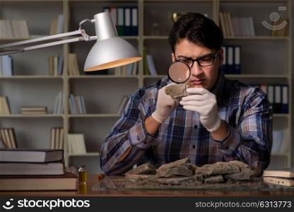 The archeologist working late night in office. Archeologist working late night in office