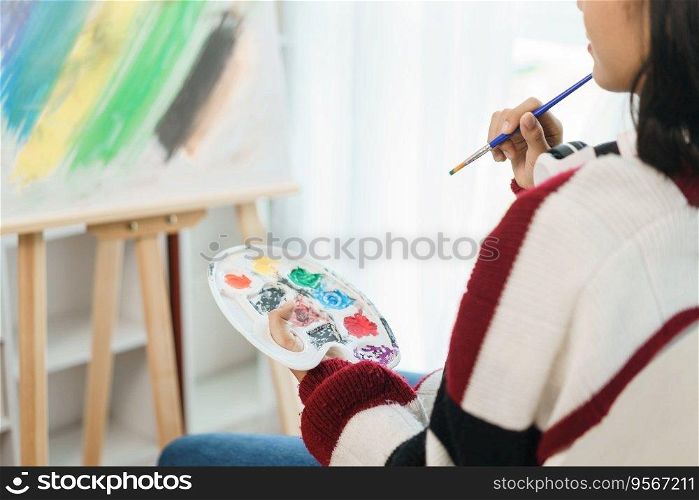 The art concept, Asian female artist sitting front of canvas and thinking to create about artwork.