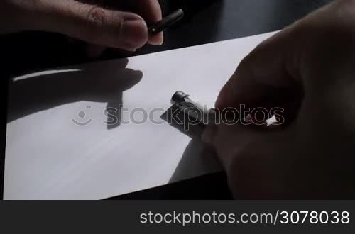 The artist inserts the pen in calligraph and preparing lattering typographical design.
