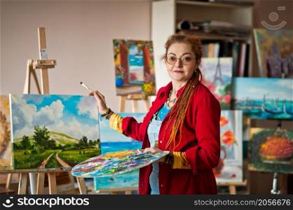 The artist paints an oil painting in her studio.. The process of painting an oil painting 2915.