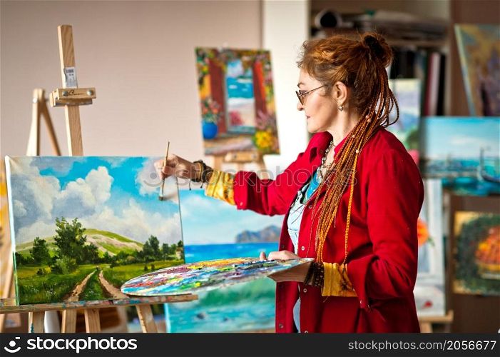 The artist paints an oil painting in her studio.. The process of painting an oil painting 2916.