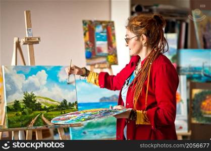 The artist paints an oil painting in her studio.. The process of painting an oil painting 2916.