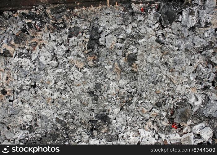 The Ashes. Remains of burned firewood with red-hot embers fragments
