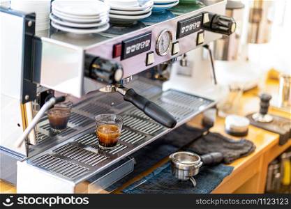 The atmosphere of the coffee shop has an automatic coffee machine which is running. The aroma of fragrant espresso coffee.close-up image of the coffee machines that are operating automatical Coffee flowing into coffee cup.