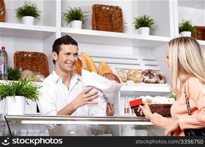The attractive girl buys bread in shop