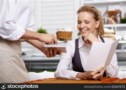The attractive girl dictates the order in cafe