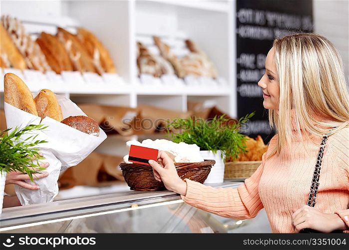 The attractive girl stretches a credit card in shop