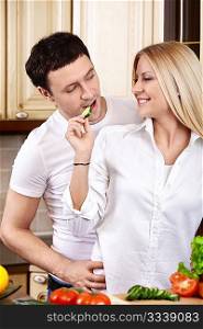 The attractive girl treats the young man on kitchen