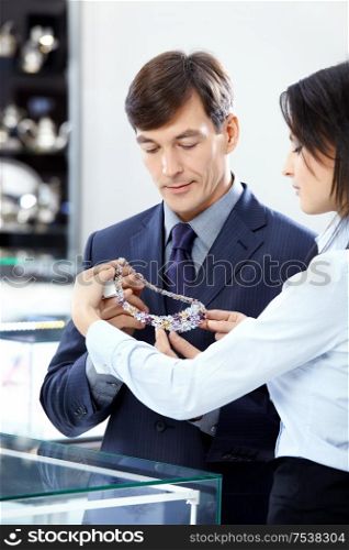 The attractive man chooses a jewel in shop