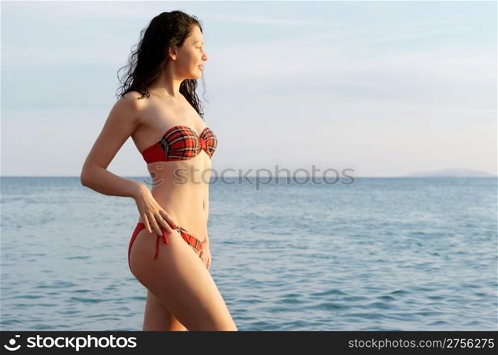 The attractive woman on seacoast. The nice young girl against the sea