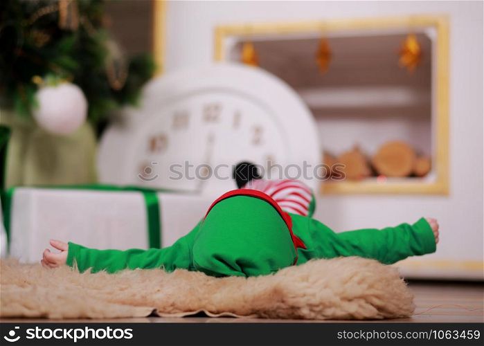 The baby is lying in christmas gnome costume in christmas studio. The costume for the New year. A newborn baby boy. The baby is lying in christmas gnome costume in christmas studio. The costume for the New year. A newborn baby boy.